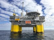 Majestic offshore oil platform in Norway's North Sea, under blue skies.